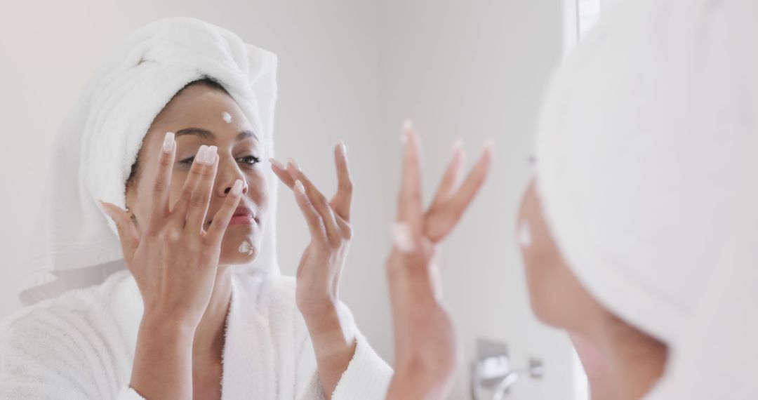 Biracial Woman Applying Face Cream in Bathroom for Self Care Routine - Free Images, Stock Photos and Pictures on Pikwizard.com