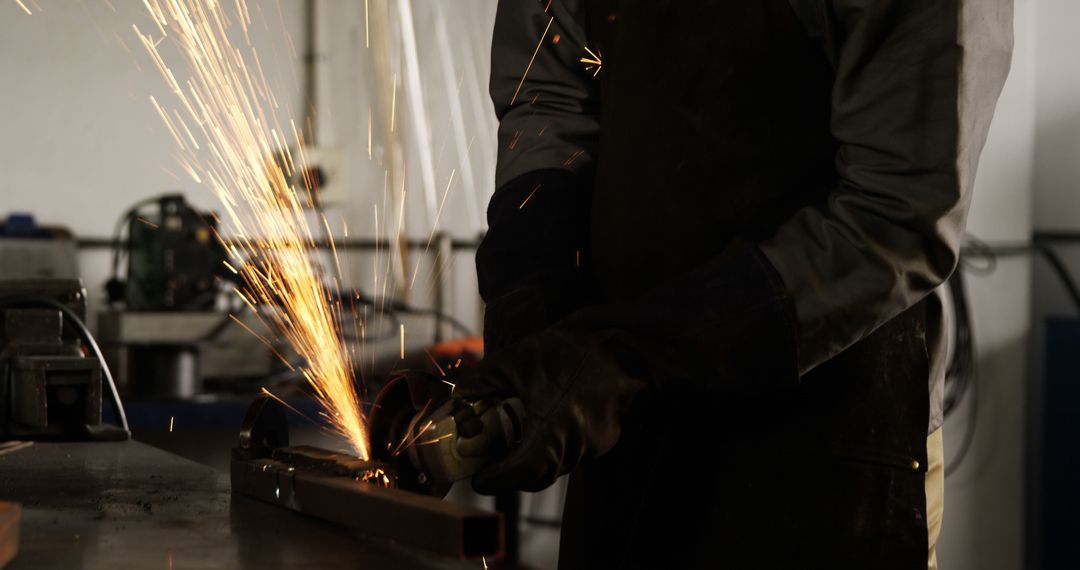 Worker Grinding Metal with Sparks Flying in Workshop - Free Images, Stock Photos and Pictures on Pikwizard.com