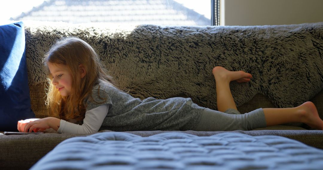 Girl Relaxing on Sofa Using Tablet Indoors - Free Images, Stock Photos and Pictures on Pikwizard.com