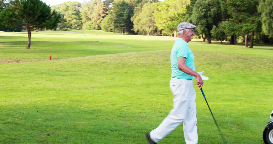 Senior Golfer Walking On Lush Golf Course