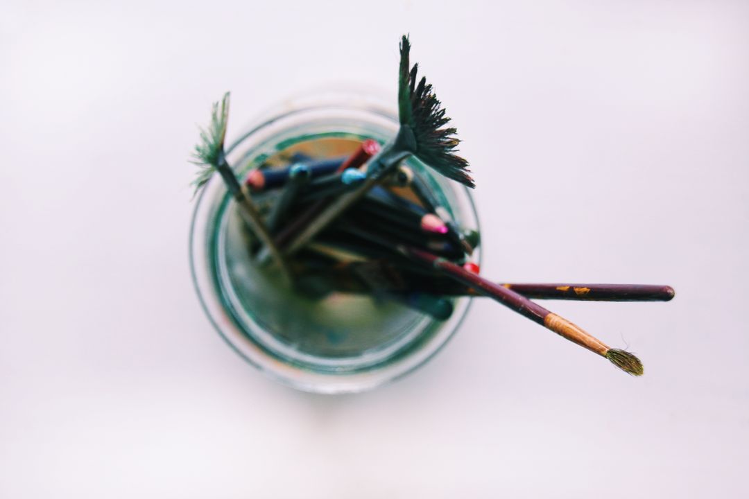 Top View of Paintbrushes and Colored Pencils in Jar
