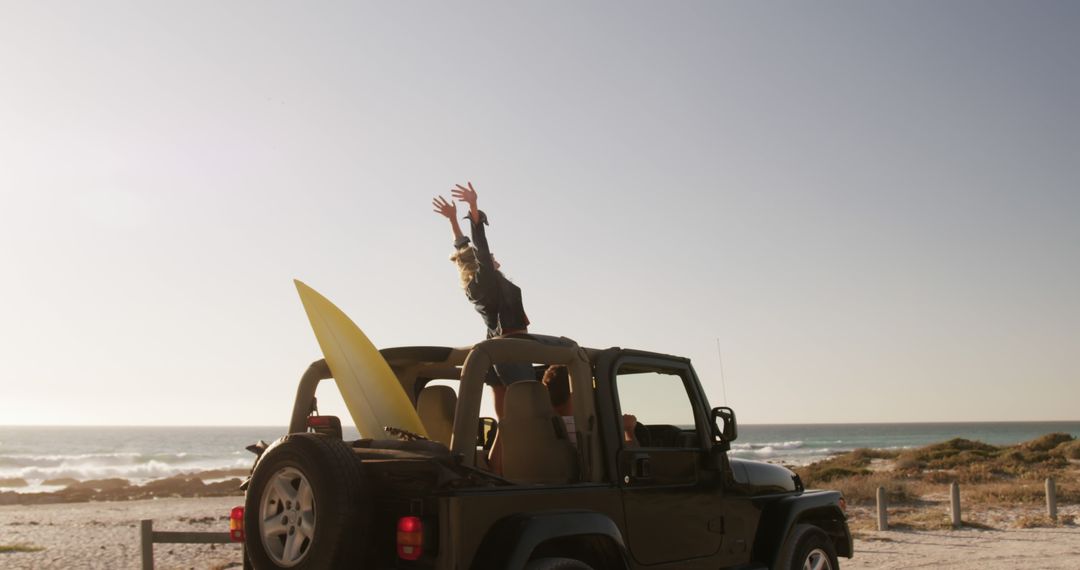 Happy Surfer Celebrating on a Jeep by the Beach at Sunset - Free Images, Stock Photos and Pictures on Pikwizard.com