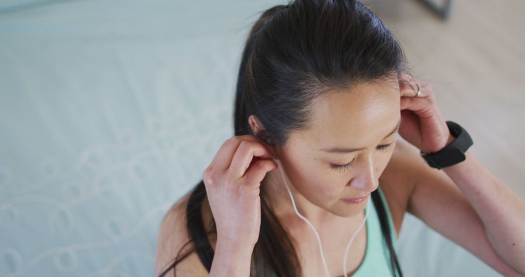 Top View of Woman Fitting Earbuds Before Exercise - Free Images, Stock Photos and Pictures on Pikwizard.com