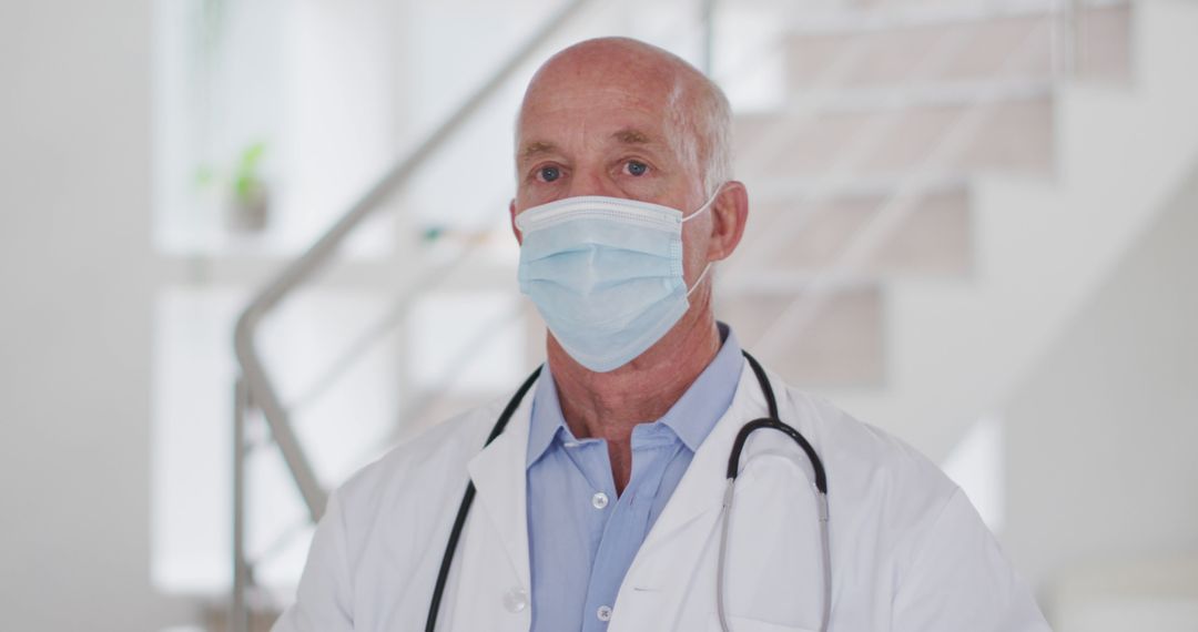 Senior Male Doctor Wearing Protective Face Mask in Clinic - Free Images, Stock Photos and Pictures on Pikwizard.com