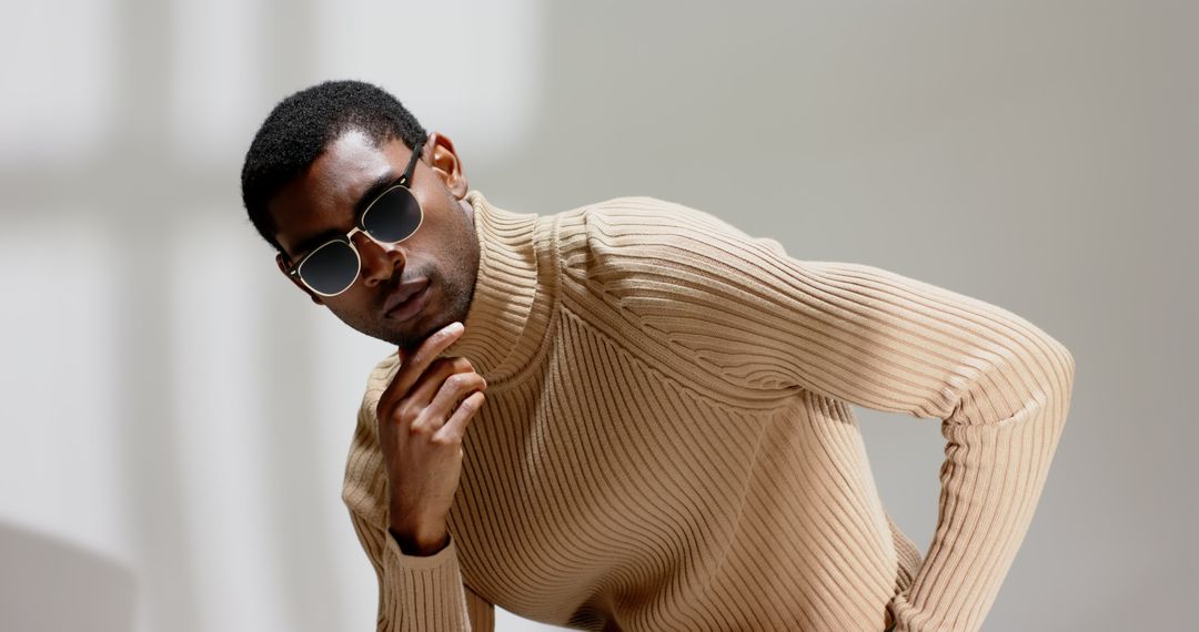 Stylish Man in Minimalist Setting Wearing Sunglasses and Sweater