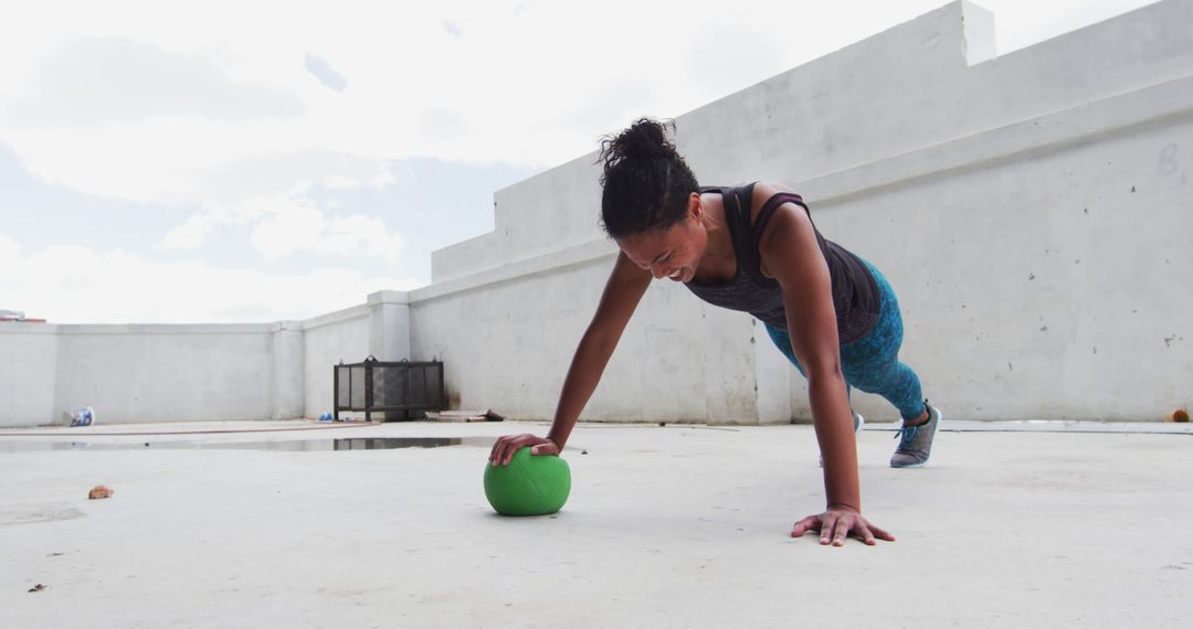 Woman doing push-up exercise on rooftop with exercise ball - Free Images, Stock Photos and Pictures on Pikwizard.com