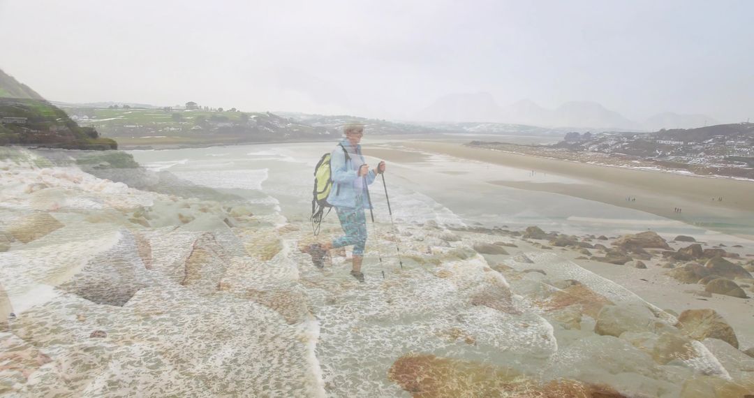 Senior Hiker Navigating Wet Coastal Rocks with Trekking Poles