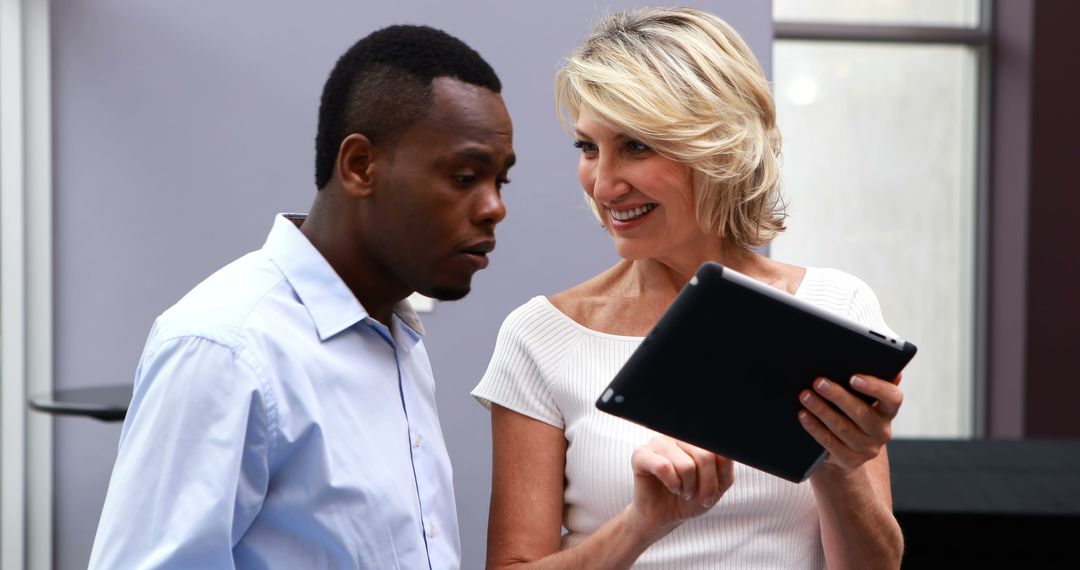 Middle-Aged Professionals Discussing Ideas Over Digital Tablet