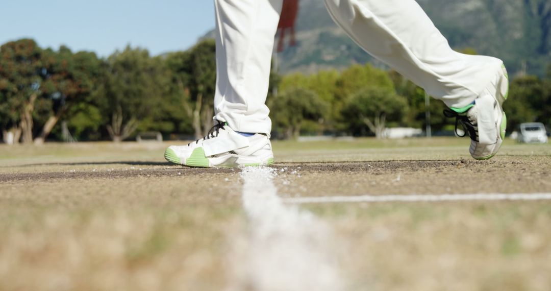 Close-Up of Cricketer Stepping Onto Pitch in White Uniform and Green Shoes - Free Images, Stock Photos and Pictures on Pikwizard.com