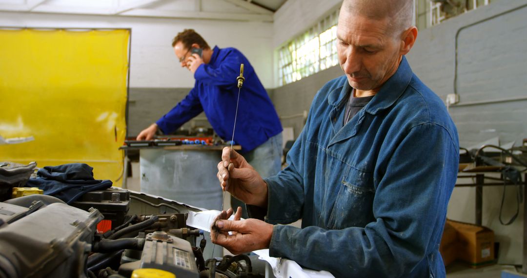 Auto Mechanics Working in Garage, Diagnosing Car Problems and Discussing Repairs - Free Images, Stock Photos and Pictures on Pikwizard.com