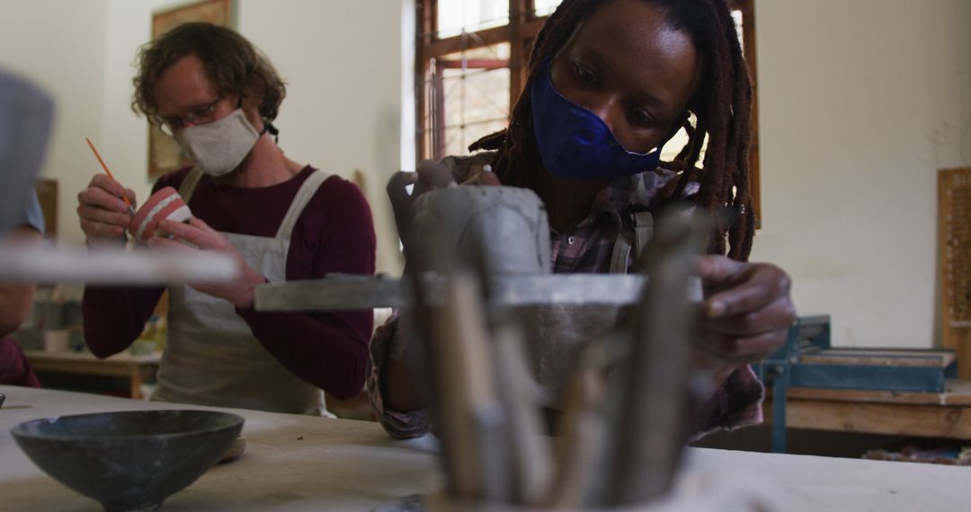 Artists Wearing Masks Creating Pottery in Studio - Free Images, Stock Photos and Pictures on Pikwizard.com