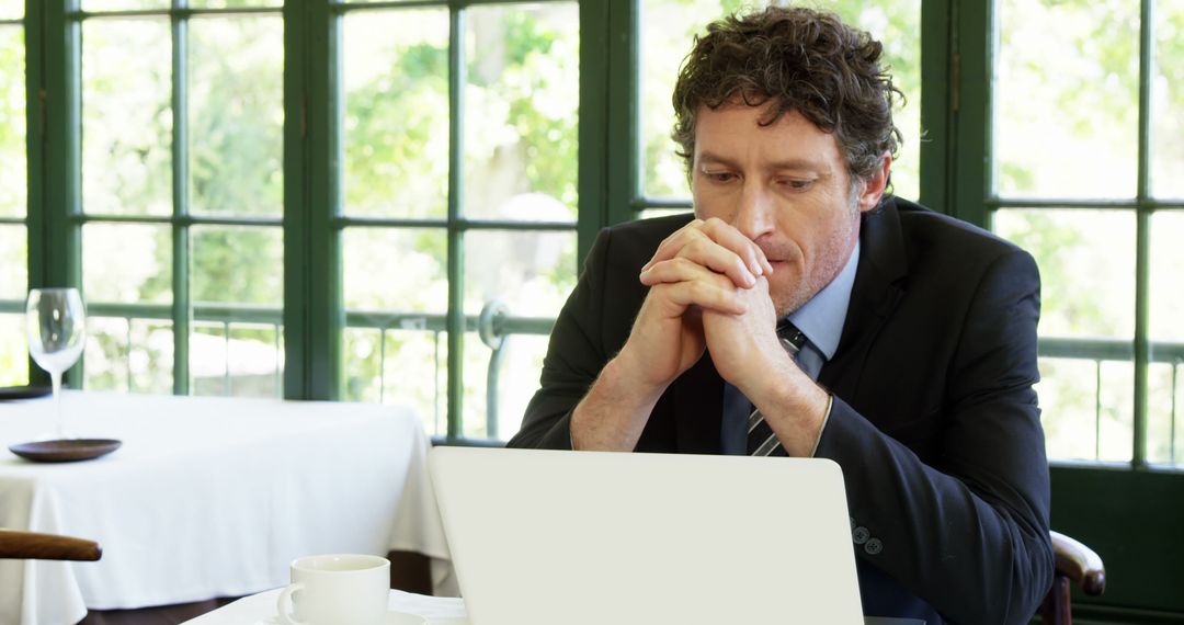 Businessman Thinking Deeply While Working on Laptop in Cafe - Free Images, Stock Photos and Pictures on Pikwizard.com