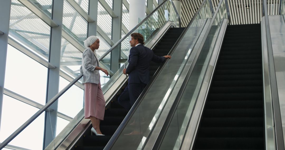 Business Professionals in Conversation on Office Escalator - Free Images, Stock Photos and Pictures on Pikwizard.com