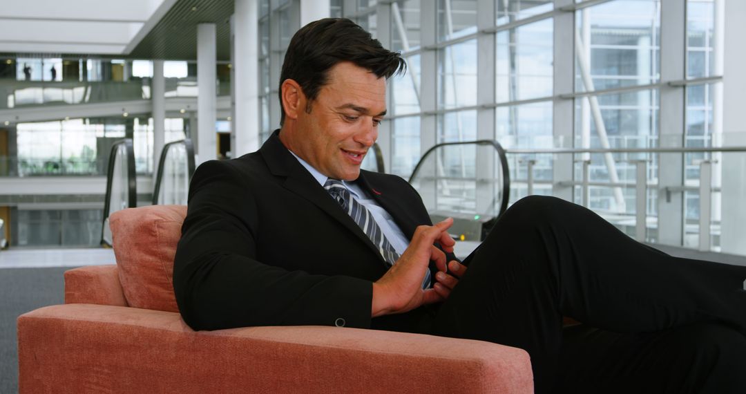 Businessman Relaxing with Smartphone in Modern Office Building - Free Images, Stock Photos and Pictures on Pikwizard.com