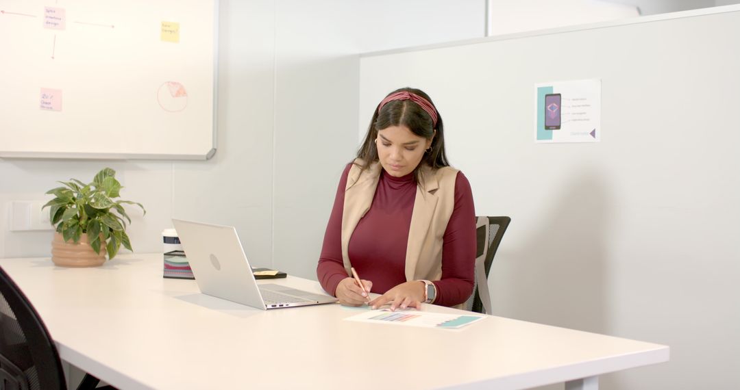 Businesswoman Analyzing Color-Coded Charts at Workspace