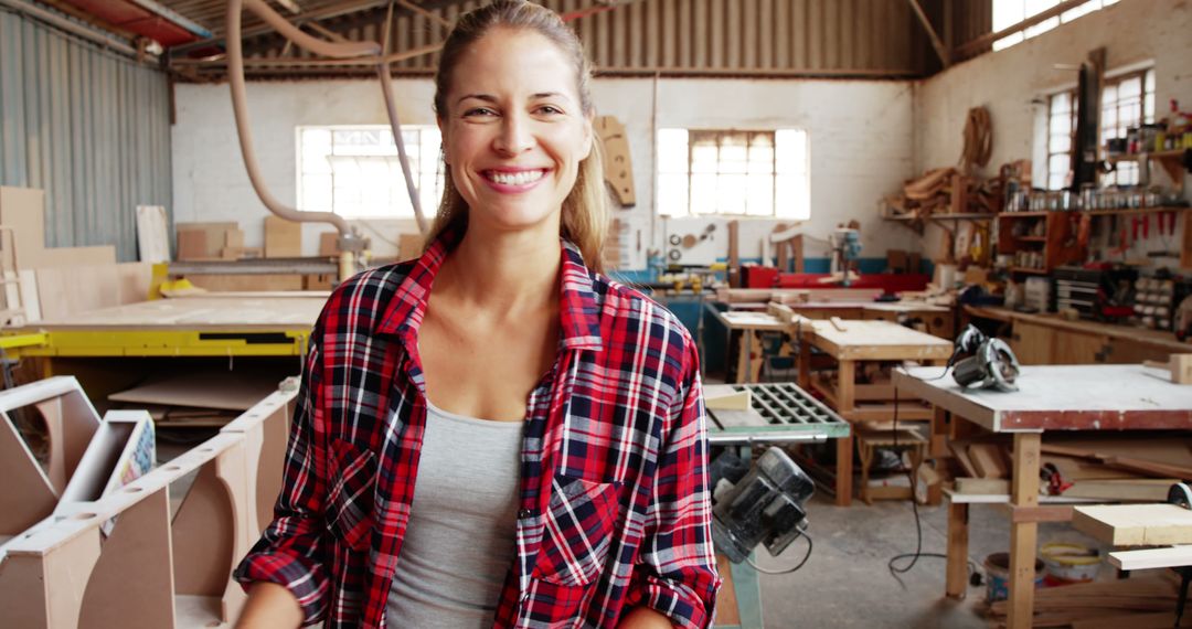 Confident Female Carpenter Smiling in Wood Workshop - Free Images, Stock Photos and Pictures on Pikwizard.com