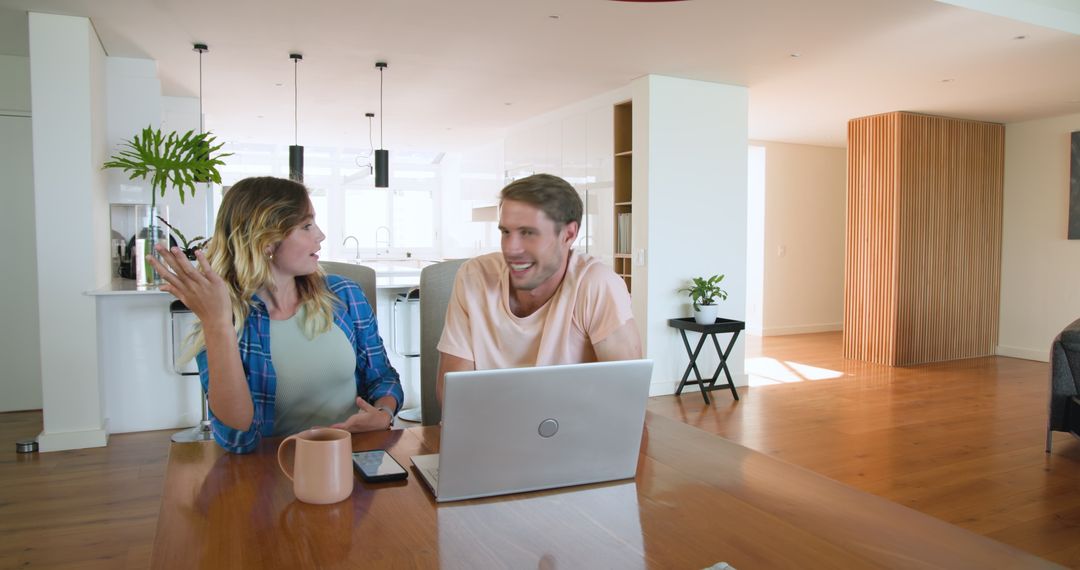 Couple Discussing Plans Using Laptop at Home