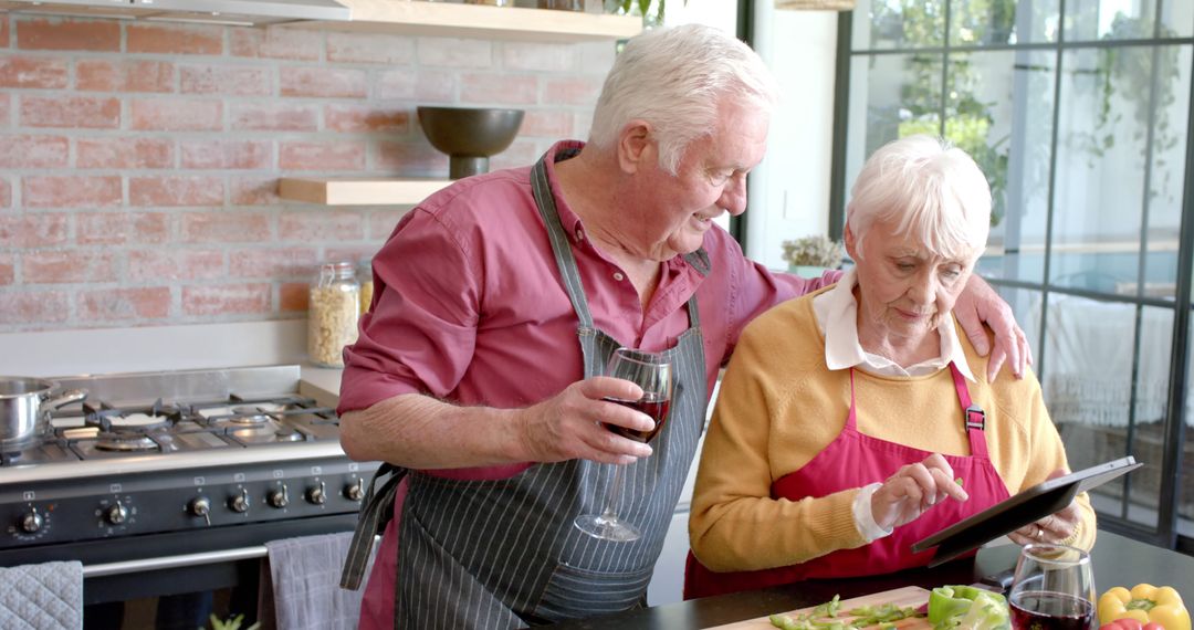 Senior Couple Cooking Together in Modern Kitchen Using Tablet