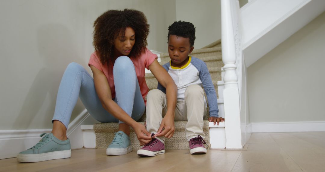 Mother Tying Son's Shoes on Staircase at Home - Free Images, Stock Photos and Pictures on Pikwizard.com