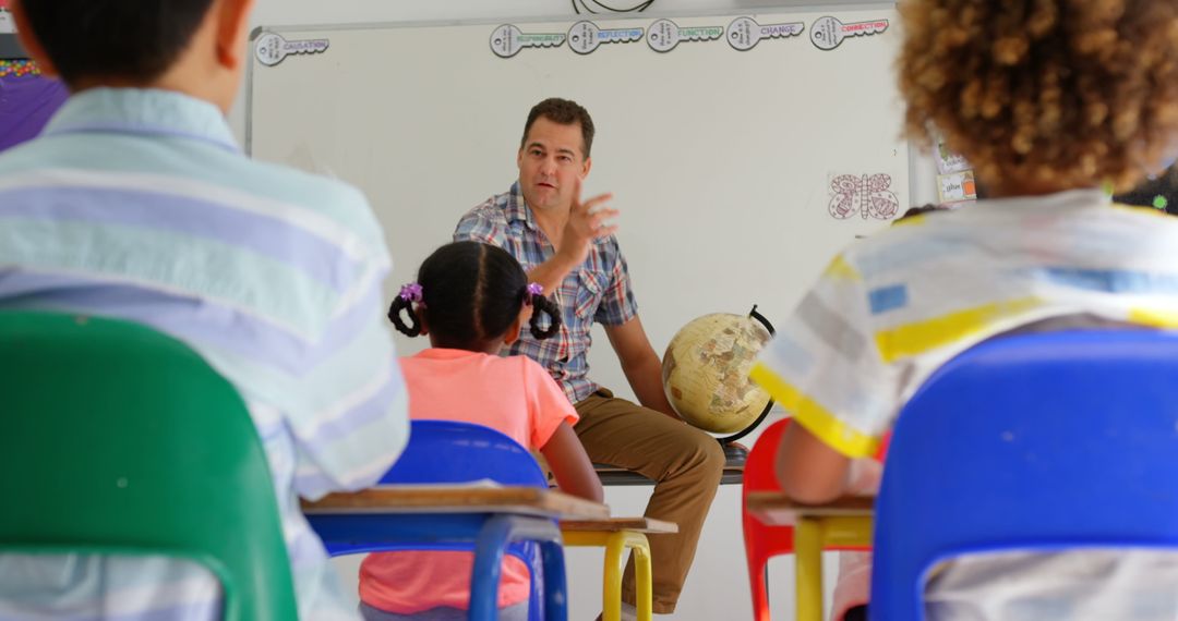 Male Teacher Engaging Diverse Students with Globe in Classroom Setting