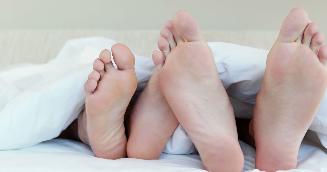 Couple Lying in Bed with Bare Feet Under Covers - Free Images, Stock Photos and Pictures on Pikwizard.com