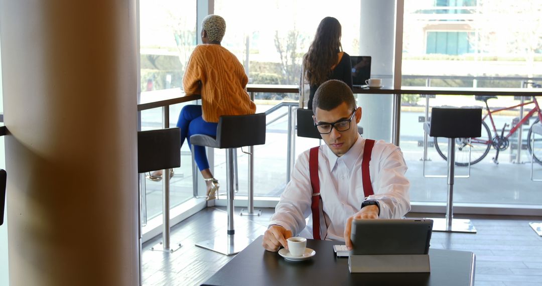 Businessman Using Tablet in Modern Cafe with Coffee - Free Images, Stock Photos and Pictures on Pikwizard.com