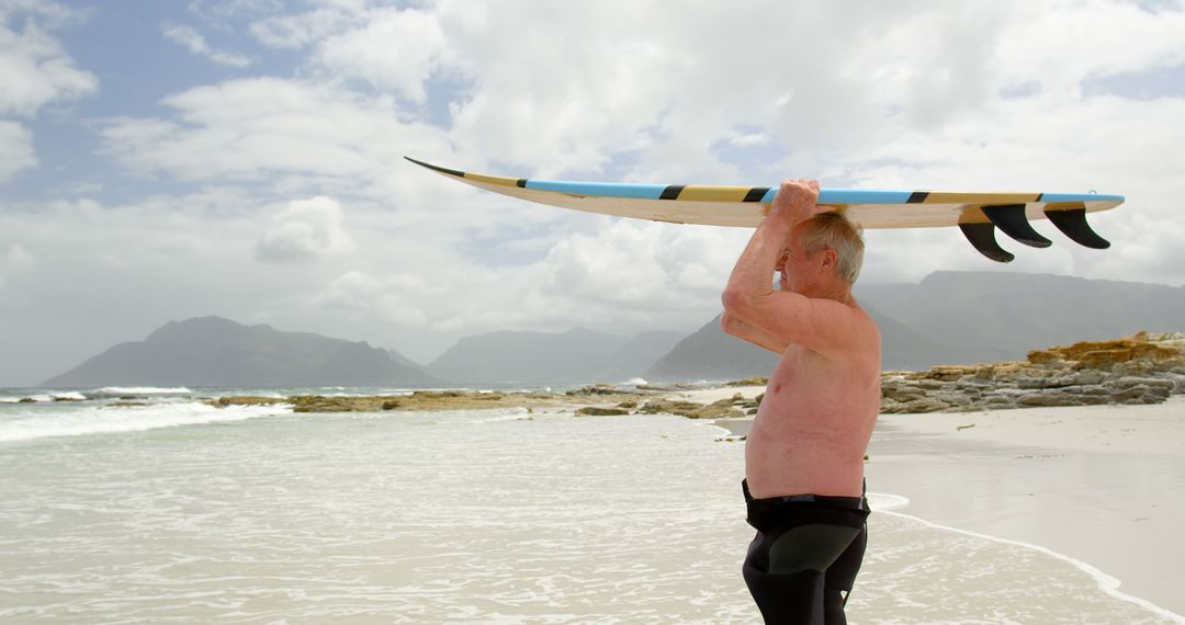 Senior Man Ready to Surf on Coastal Beach - Free Images, Stock Photos and Pictures on Pikwizard.com