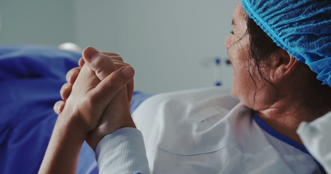 Close-up of man comforting pregnant woman during labor in operation theater at hospital - Free Images, Stock Photos and Pictures on Pikwizard.com