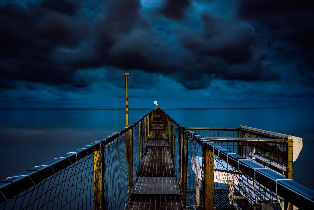 Dramatic Cloudy Sky over Pier at Night - Free Images, Stock Photos and Pictures on Pikwizard.com