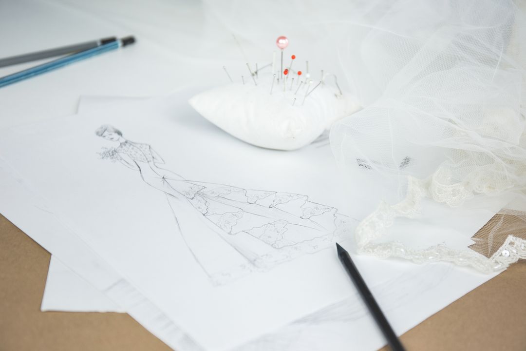 Bridal Dress Design with Sketch and Sewing Tools on White Table