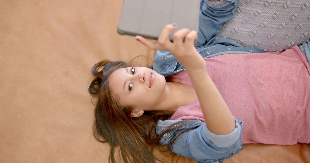 Girl Smiling While Using Tablet and Relaxing on Couch