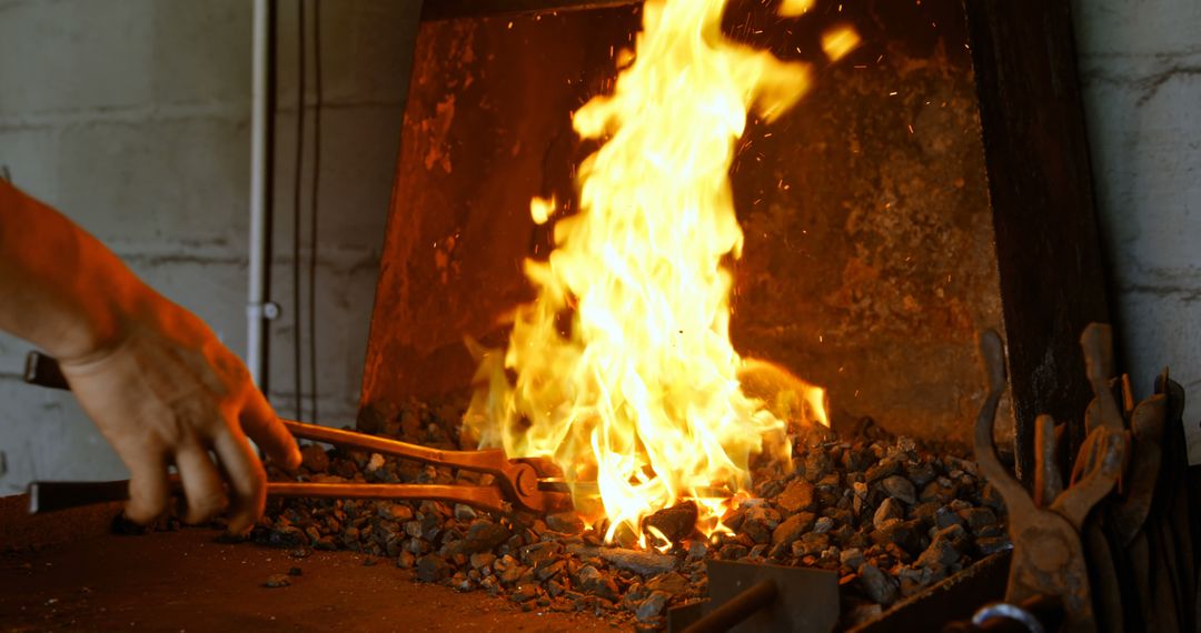 Blacksmith Preparing Forge with Burning Flames and Tongs - Free Images, Stock Photos and Pictures on Pikwizard.com