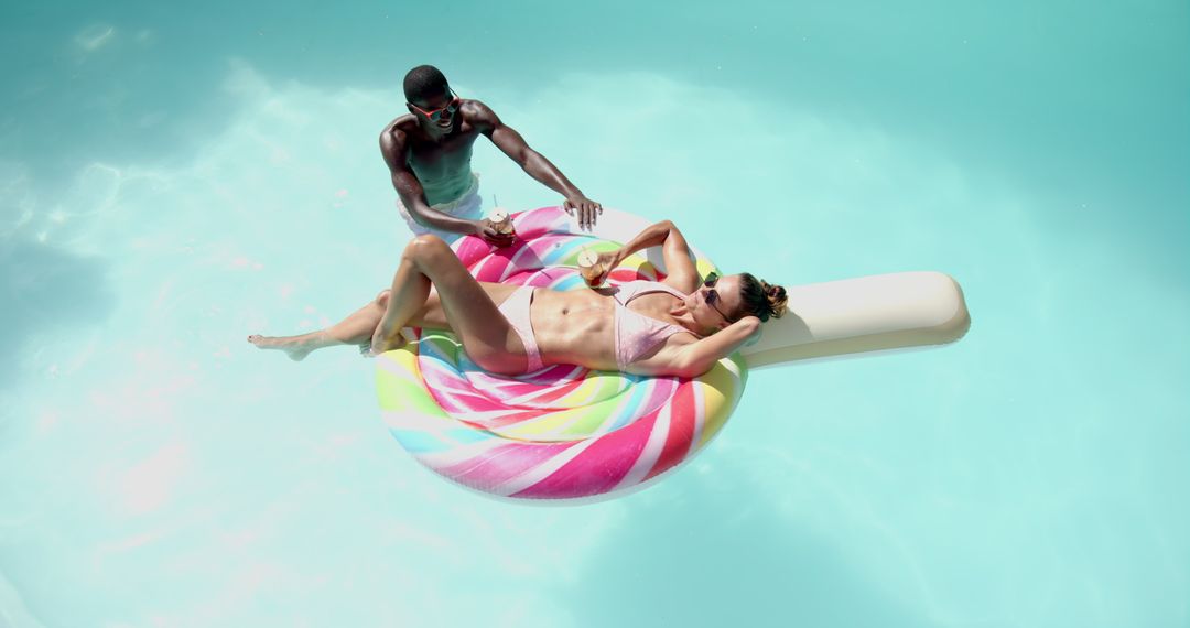Young Couple Relaxing on Vibrant Pool Float in Summer Sun