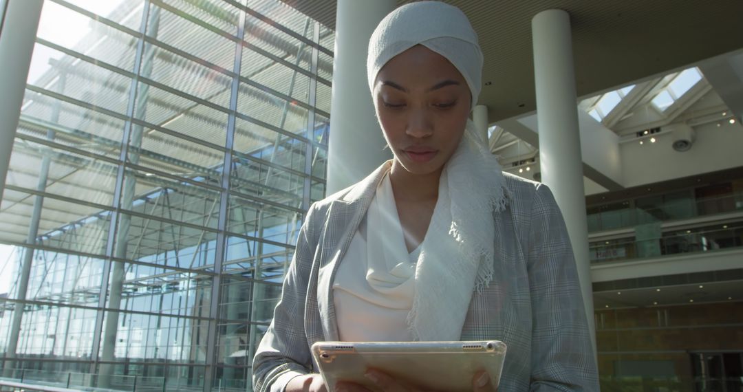 Muslim businesswoman reviews documents on a tablet in an office setting - Free Images, Stock Photos and Pictures on Pikwizard.com