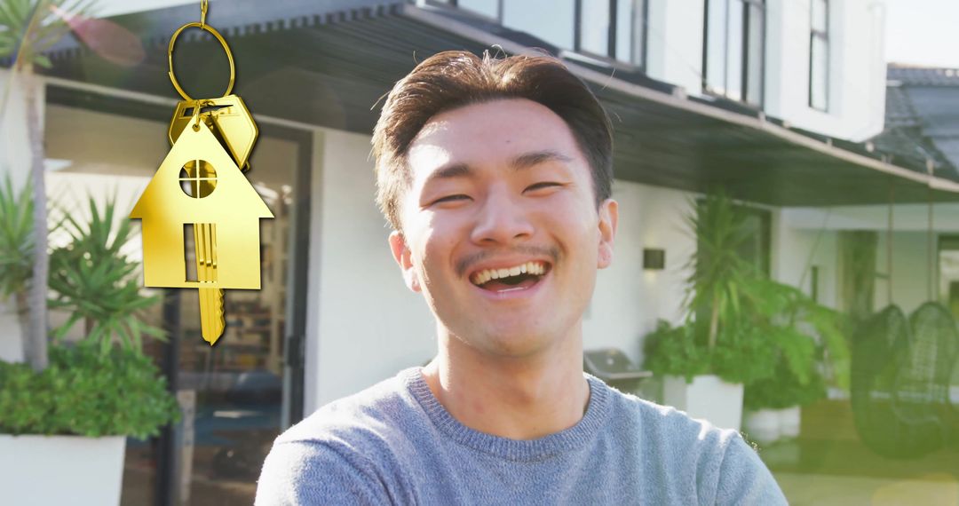 Happy Homeowner Standing with Gold House Key in Front of House