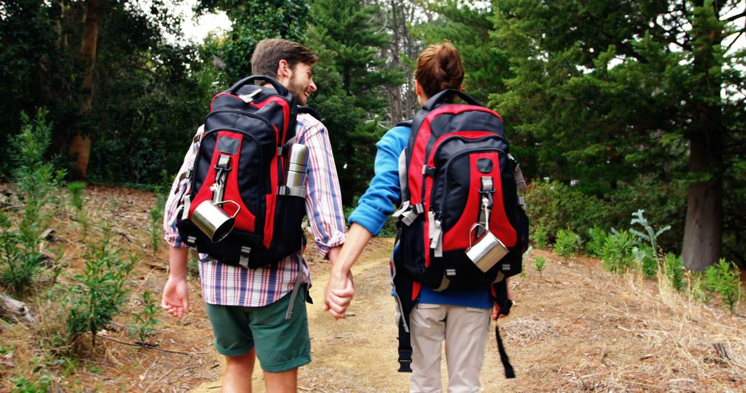 A young Caucasian couple is hiking in a forested area, with copy space - Free Images, Stock Photos and Pictures on Pikwizard.com