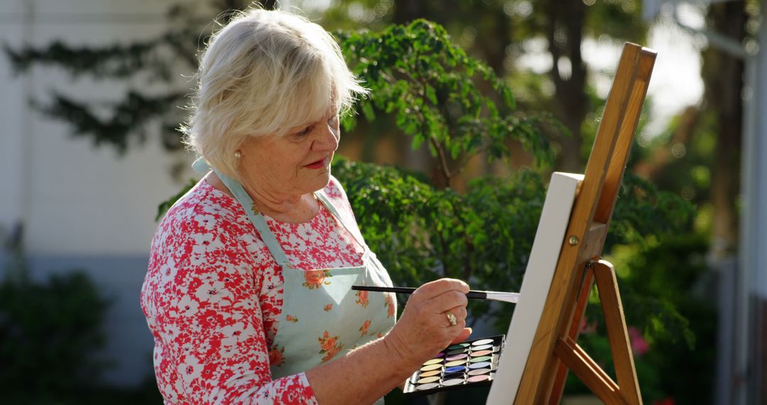 Senior Woman Painting Outdoors on a Sunny Day - Free Images, Stock Photos and Pictures on Pikwizard.com