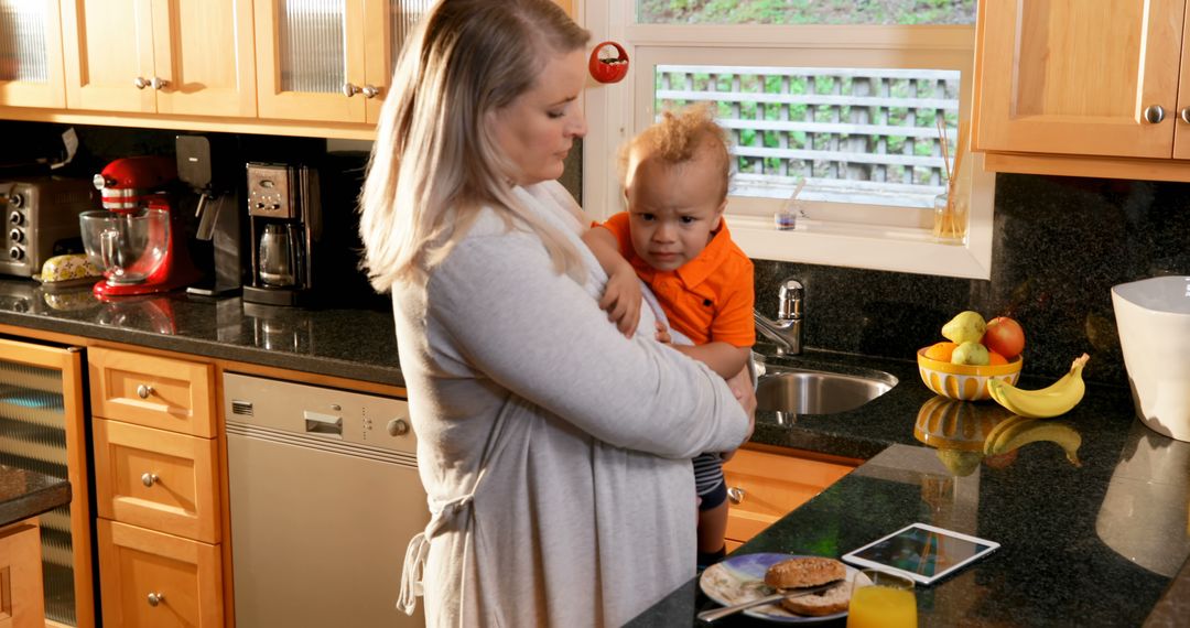 Mother Comforting Child in Modern Kitchen with Breakfast Items - Free Images, Stock Photos and Pictures on Pikwizard.com