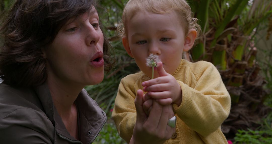 Mother and Toddler Blowing Dandelion in Garden - Free Images, Stock Photos and Pictures on Pikwizard.com