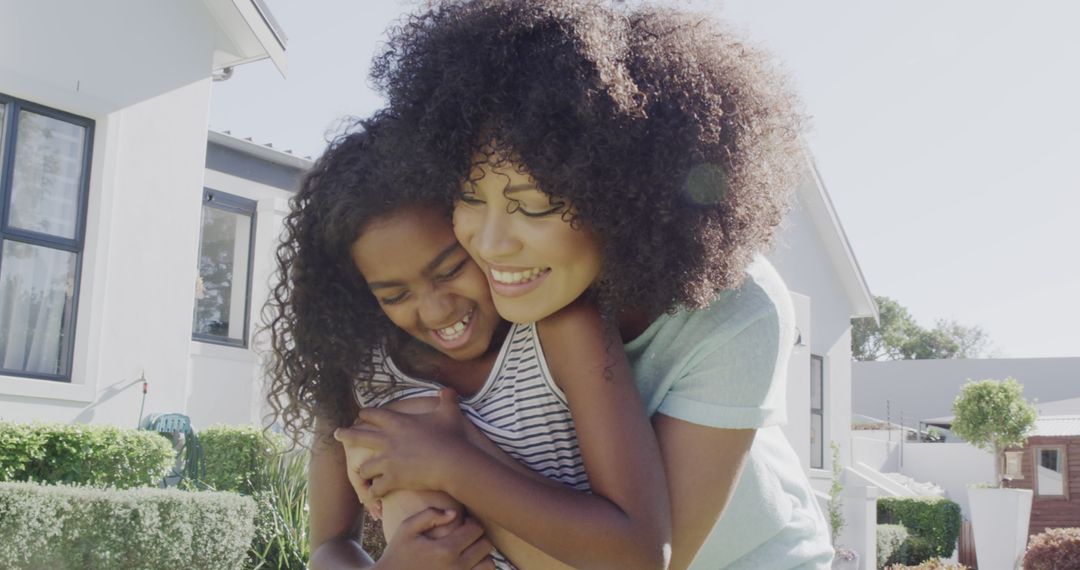 Happy Mother and Daughter Embracing in Suburban Backyard - Free Images, Stock Photos and Pictures on Pikwizard.com