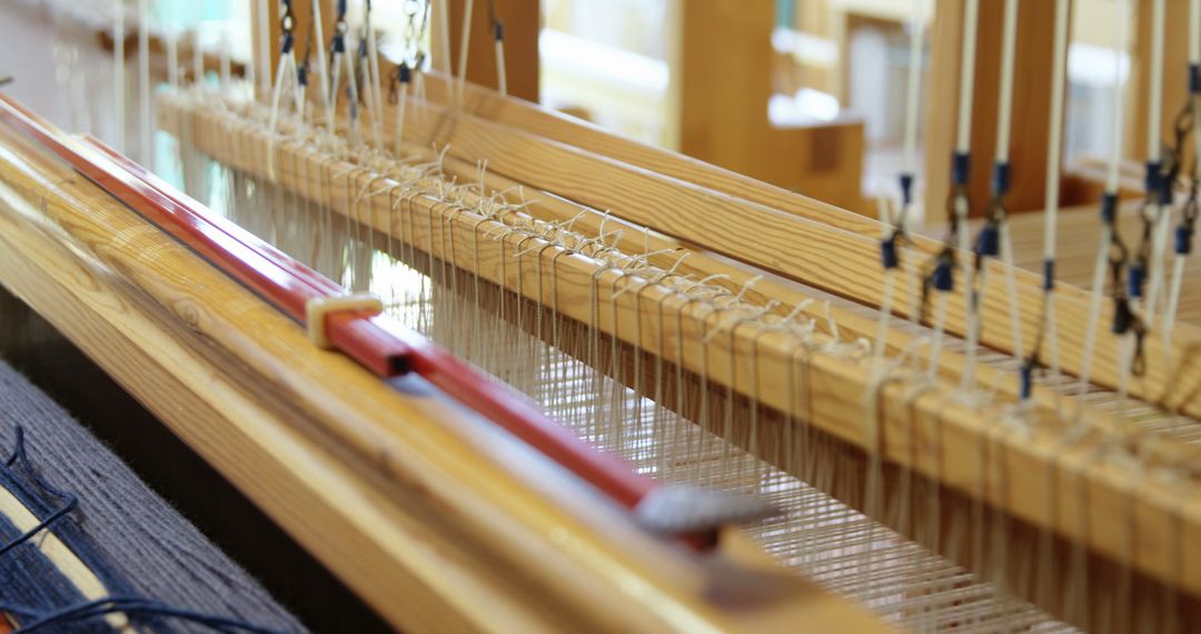 Close-Up of Threaded Hand Loom in Solar-Powered Workshop