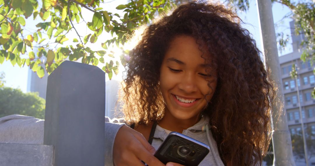 Young Woman Enjoying Outdoor Sunshine while Using Smartphone - Free Images, Stock Photos and Pictures on Pikwizard.com