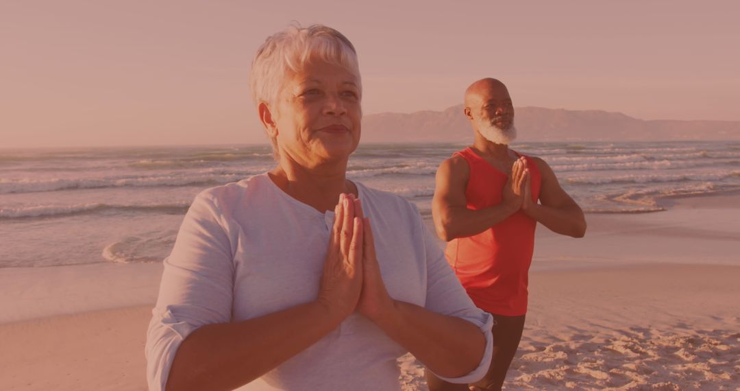 Senior Couple Meditating on Serene Beach at Sunset