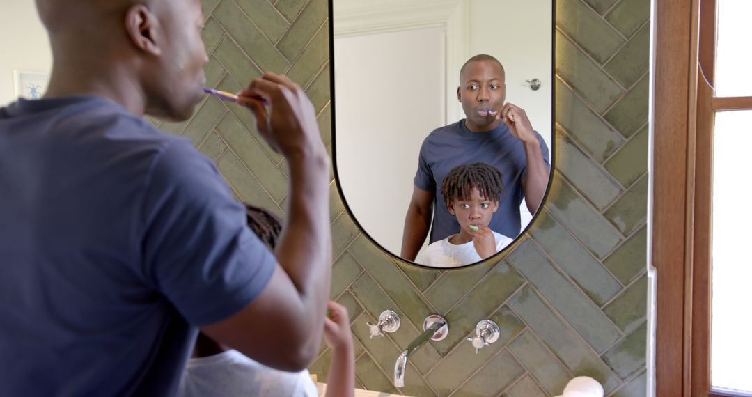 Father and son brushing teeth together in bathroom - Free Images, Stock Photos and Pictures on Pikwizard.com