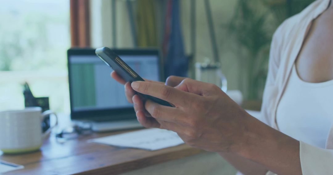Business Professional Using Smartphone in Modern Home Office Workspace