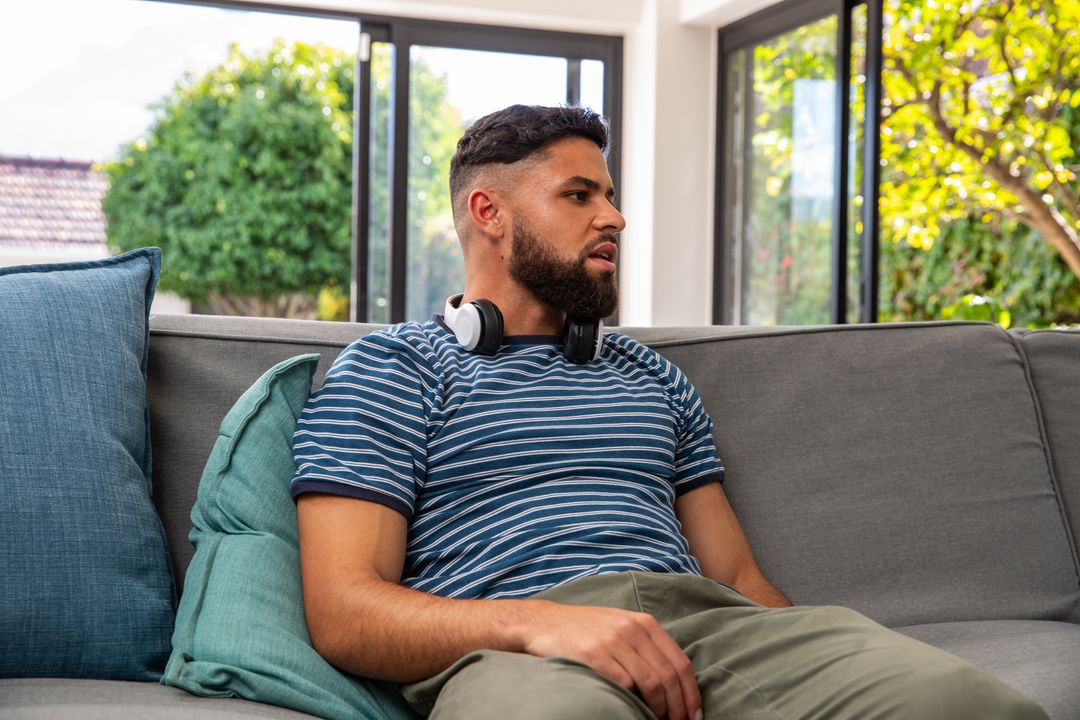Casual Relaxation: Man Lounging on Sofa with Headphones