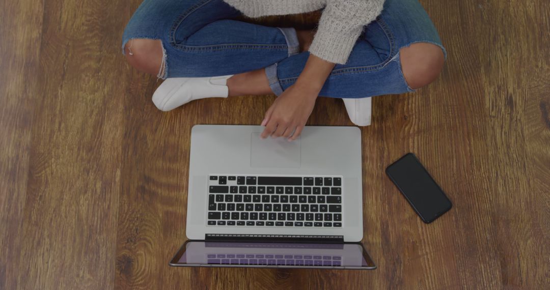 Person Using Laptop While Sitting on Wooden Floor - Free Images, Stock Photos and Pictures on Pikwizard.com