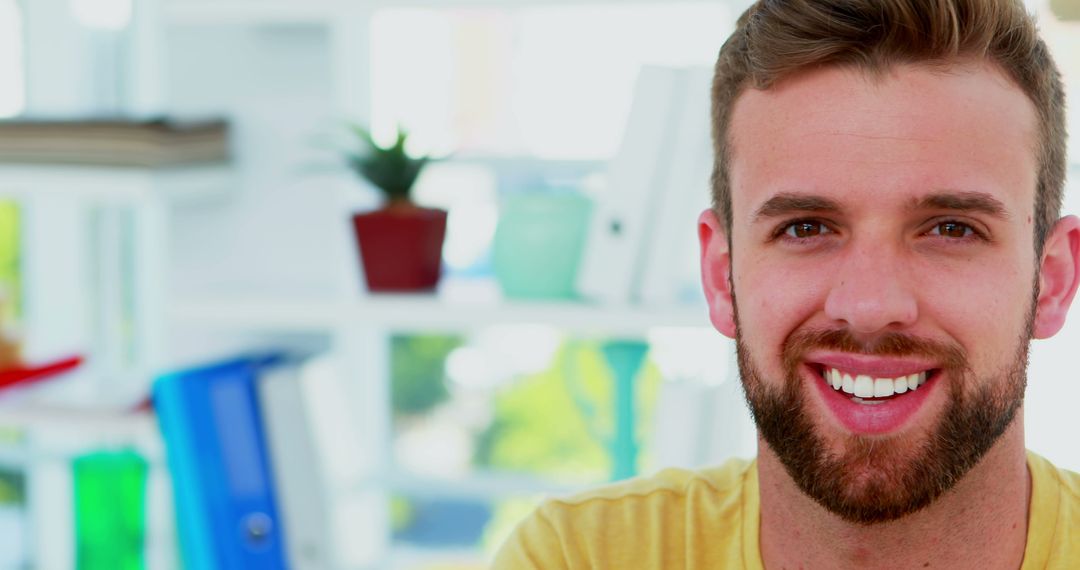 Smiling Young Man with Beard Posing in Bright Office - Free Images, Stock Photos and Pictures on Pikwizard.com