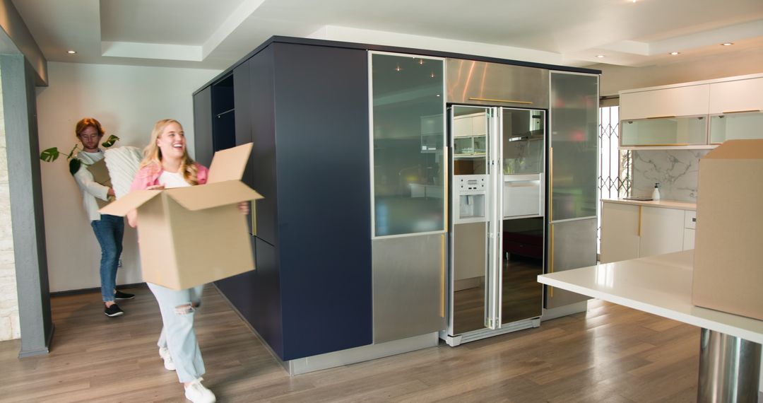 Young Couple Unpacking Boxes in Modern Kitchen While Moving House