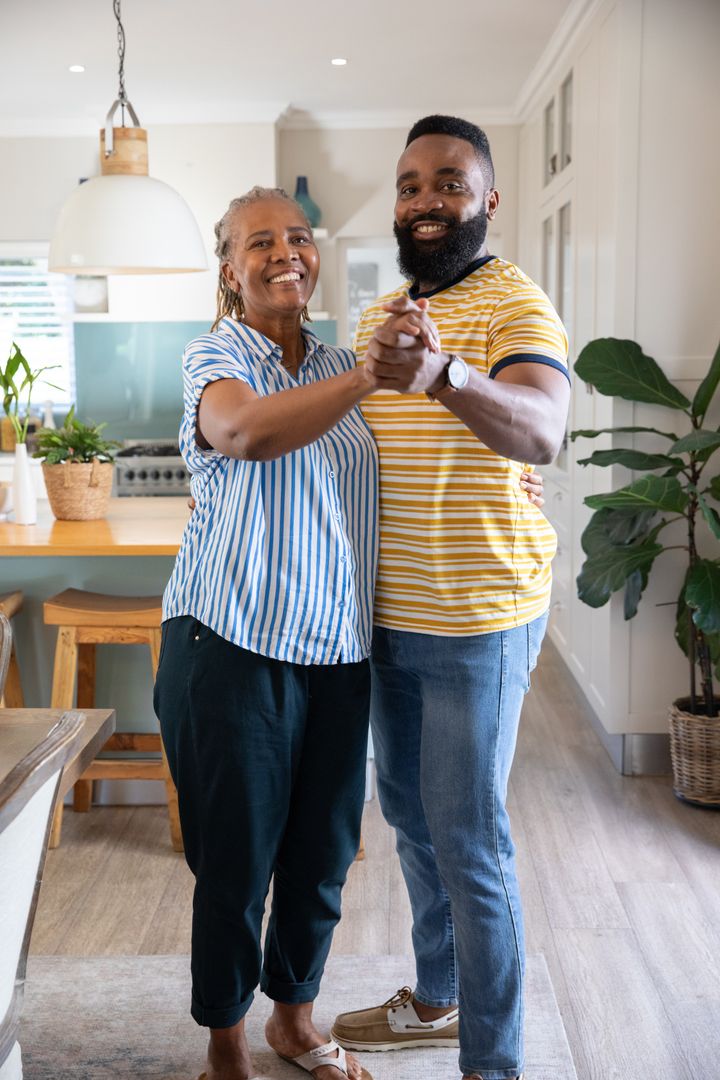 Mother and Son Dancing Joyfully in Modern Kitchen